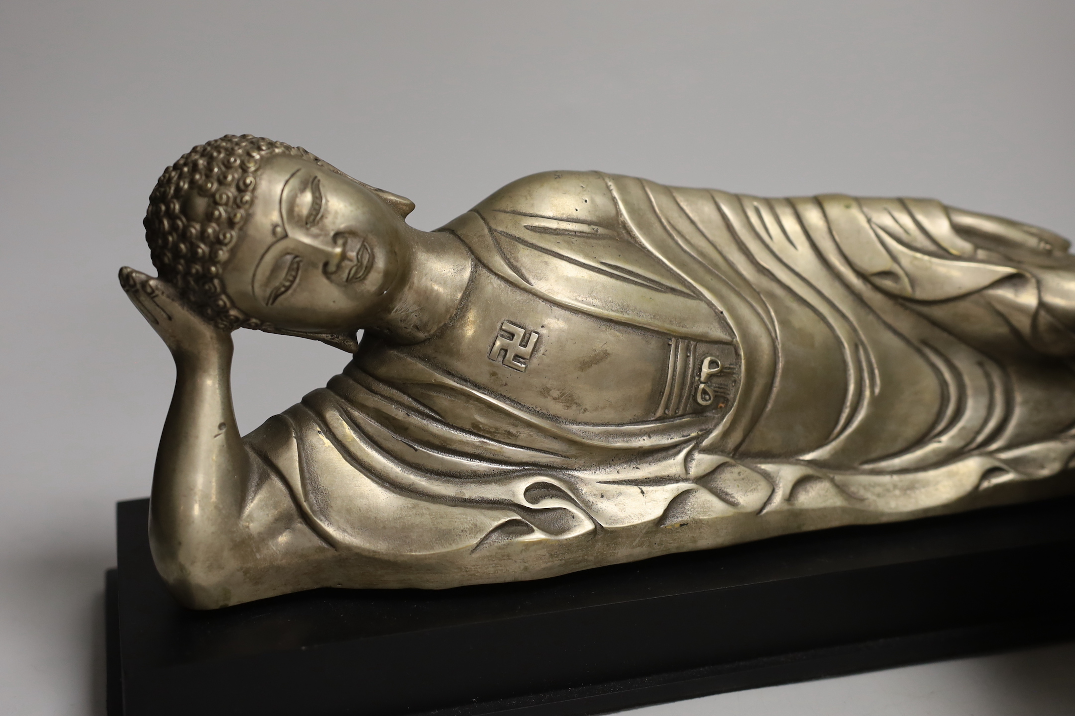 A Chinese silvered metal reclining Buddha and a two handled censer, reclining Buddha 41cm wide